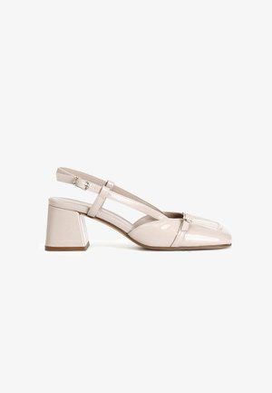 Beige patentlæder slingback sko med firkantet tå, bred blokhæl og crisscross stropdesign med en lille spænde detalje.