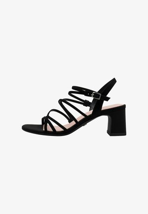 Black strappy sandal with a block heel, featuring a mix of smooth and textured materials, adjustable ankle strap, and open toe design.