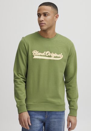 Green crewneck sweatshirt with long sleeves, featuring a textured beige "Blend Original" logo across the chest. Made of soft fabric.