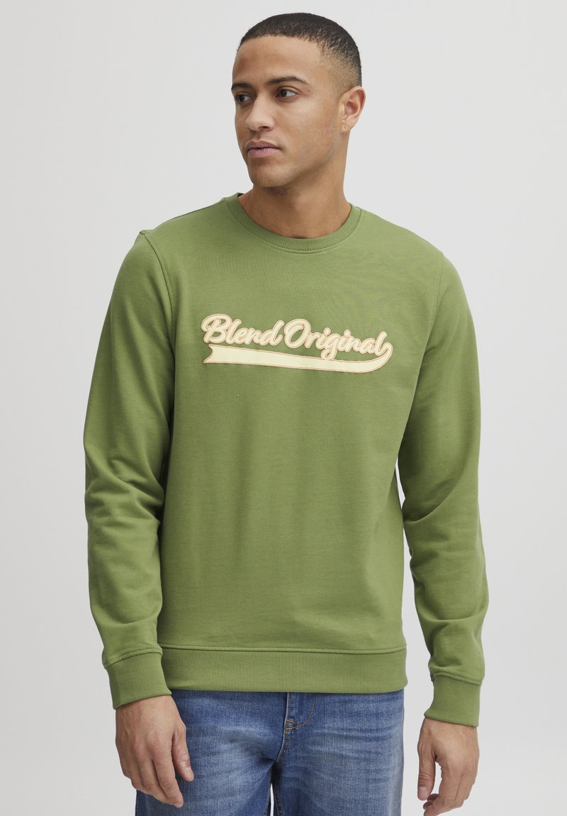Sudadera verde de cuello redondo con mangas largas, que presenta un logo texturizado en beige "Blend Original" en el pecho. Confeccionada en un tejido suave.