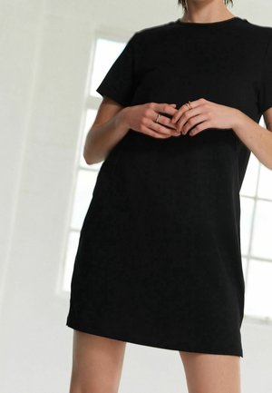 Schwarzes Baumwoll-T-Shirt-Kleid mit kurzen Ärmeln und geradem Schnitt. Der Stoff wirkt glatt und leicht mit dezenten Nahtdetails.