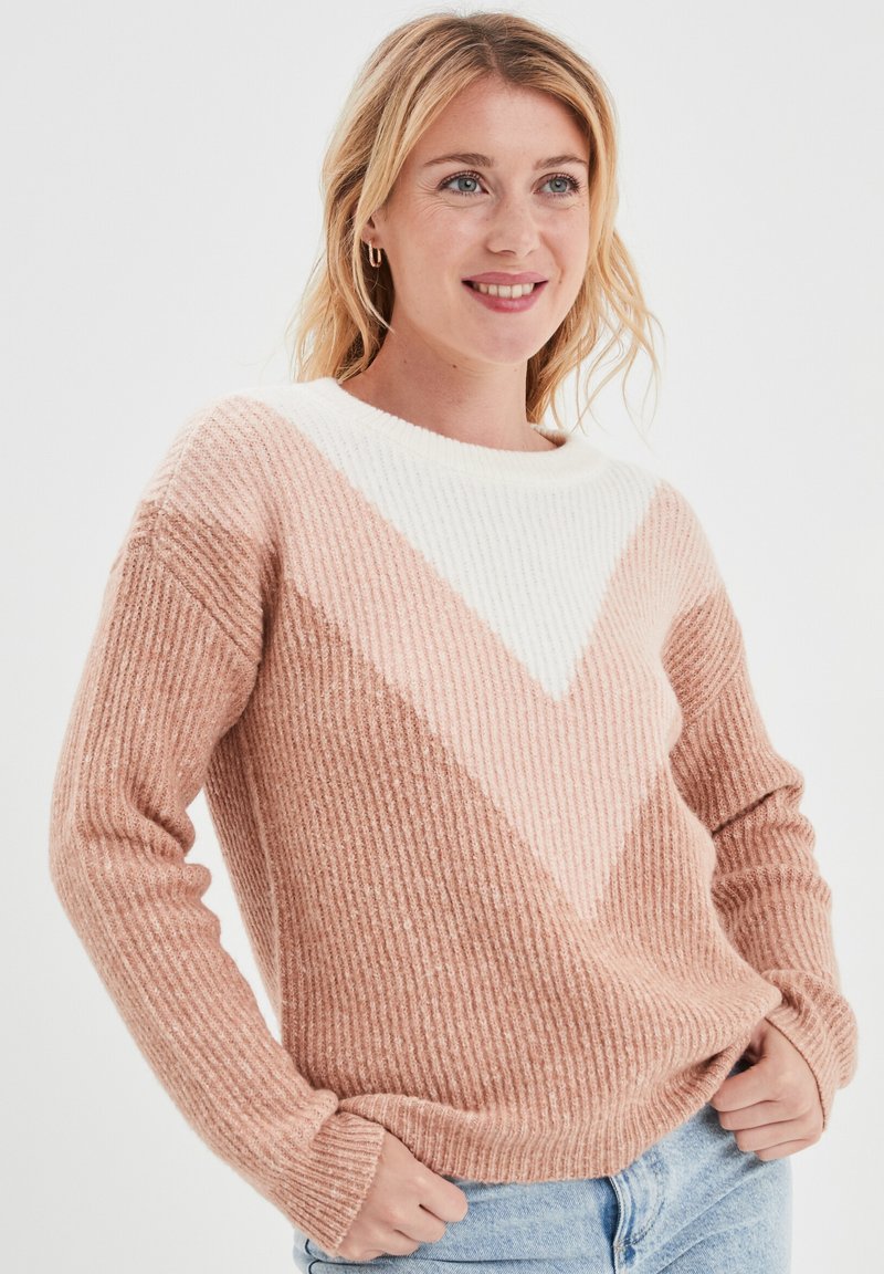 Maglione lavorato a maglia in un morbido rosa e bianco con una texture a costine. Presenta un motivo geometrico a zigzag, colletto rotondo e maniche lunghe.