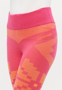 Pink leggings featuring a textured design with orange geometric patterns. The waistband is wide and ribbed, enhancing comfort and fit.