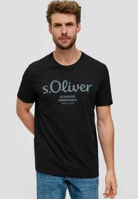 Schwarzes Baumwoll-T-Shirt mit Rundhalsausschnitt und kurzen Ärmeln. Mit einem zentrierten grauen Grafikdruck, der "s.Oliver Elevated Essentials Since 1969" lautete.