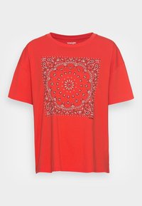 Camiseta de algodón roja con un patrón de paisley blanco y un diseño floral en el centro. Manga corta y cuello redondo. Logo de la marca en la parte inferior.