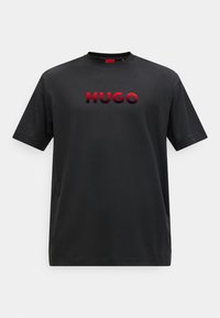Čierne bavlnené tričko s okrúhlym výstrihom, krátkymi rukávmi a vystúpeným �červeným vyšívaným logom "HUGO" cez hruď. Jednoduchý dizajn, bez vzorov.
