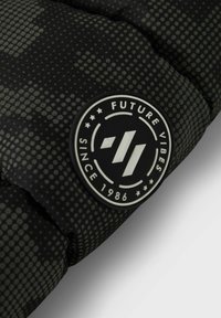 Veste matelassée noire avec une finition brillante, ornée d'un logo circulaire avec le texte "Future Vibes" et une texture en points sur tout le tissu.