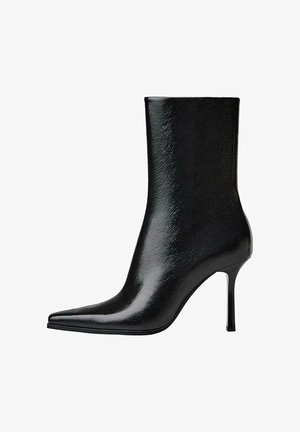 Crna kožna gležnjača sa šiljastim vrhom i tankom visokom štiklom, glatka sjajna završna obrada, bočni prikaz na bijeloj pozadini.