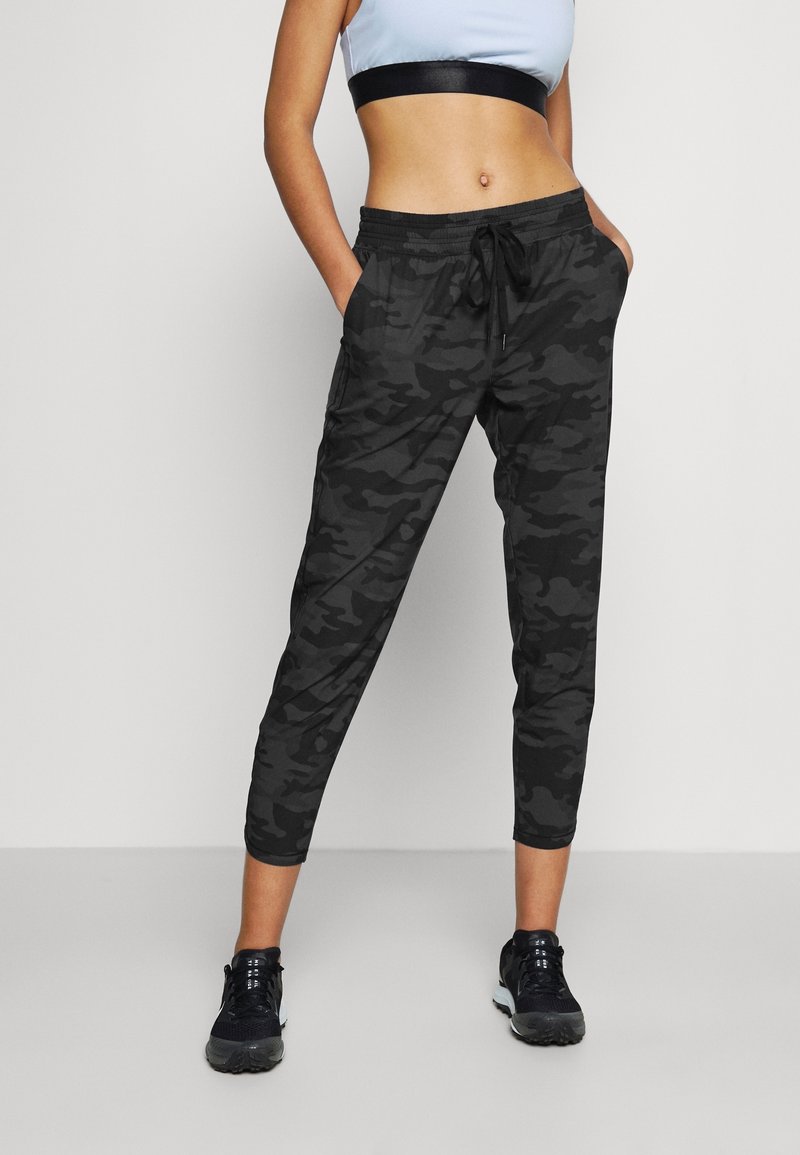 Svarta kamouflage-träningsbyxor med elastisk midja och dragsko. Taperad passform med sidofickor, tillverkade av lättviktigt material.