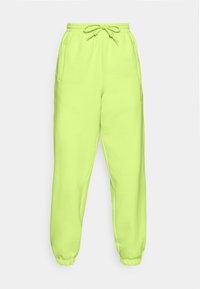 Lys limegröna sweatpants med elastisk midja, dragsko, sidofickor och elastiska muddar, uppvisade mot en vit bakgrund.