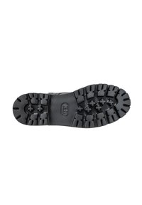 Suela de bota de goma negra con patrones de perfil profundo, diseñada para ofrecer tracción. Presenta una punta redondeada y un detalle central con el logotipo.