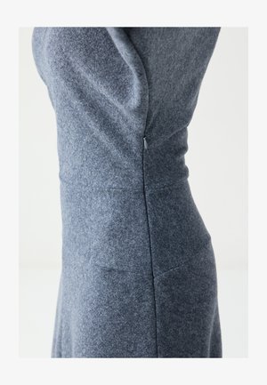 Graues Textilkleid mit figurbetontem Schnitt, vertikalen Nahtdetails und einem verdeckten Reißverschluss an der Seite. Weicher, strukturierter Stoff mit leichtem Stretch.