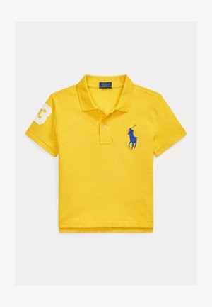 Polo en coton jaune avec une patte de boutonnage à trois boutons. Présente un logo de cheval brodé en bleu et le chiffre blanc "3" sur la manche gauche.