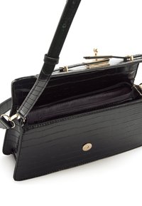 Bolso negro con relieve de cocodrilo, acabado brillante, herrajes dorados y un interior forrado con un bolsillo con cremallera y una correa ajustable.