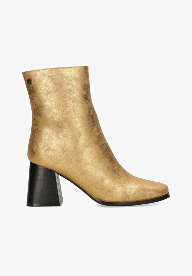 Botín dorado de tobillo fabricado en material sintético texturizado, con puntera afilada y un tacón ancho negro con estrías verticales.