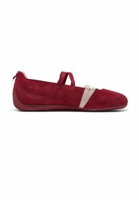 Chaussure plate en daim rouge avec semelle souple, dotée de deux sangles beiges sur le devant et d'une seule sangle rouge sur le cou-de-pied.