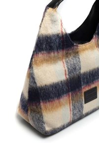 Torba w wzór houndstooth, wykonana z miękkiej wełny, z czarną skórzaną rączką; zawiera kolory takie jak granatowy, beżowy i czerwone akcenty.