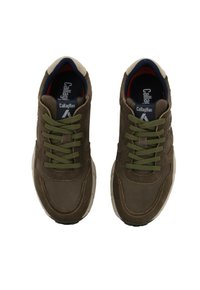Zapatillas de ante marrón con cordones verdes, suela blanca e interior azul marino. Detalles de costura destacados en el lateral y marca en la lengüeta visibles.