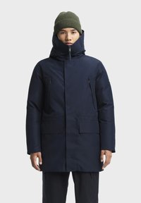 Marineblauwe parka-jas gemaakt van waterafstotend materiaal, met een hoge kraag, dubbele ritszakken en een knoopsluiting.