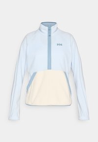 Ανοιχτό μπλε φλις πουλόβερ με σχεδίαση με φερμουάρ μέχρι τη μέση, εκρού πάνελ μπροστινής τσέπης, πλαϊνές τσέπες και μικρό μπλε λογότυπο στο στήθος.