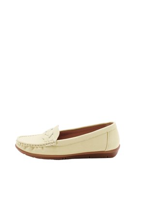 Beige lederen loafer met een bruine rubberen zool, mocassin-stiksels en een decoratieve riem aan de bovenkant, zijaanzicht.