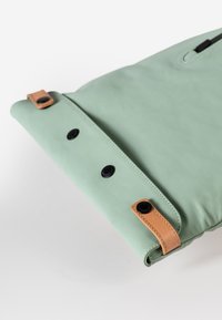 Groene leren tas met een gladde textuur, voorzien van een omklapbare flap, zwarte knopen en bruine leren accenten.