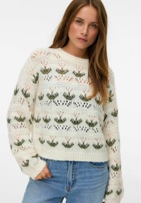 Pull en tricot couleur écru avec des motifs floraux en rose et vert. Il présente un col rond, des bords-côtes aux poignets et des détails ajourés tout au long.