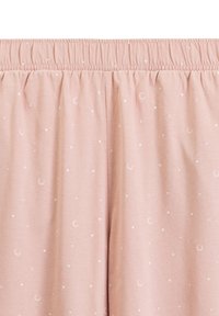 Różowy materiał w białe półksiężyce i gwiazdy, z elastycznym, marszczonym pasem. 