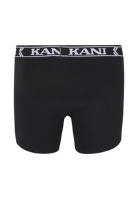 Melnas bokseru bikses ar baltu elastīgu jostu, kurā trešajā pozīcijā ir uzraksti "KAN" un "KANI" treknā baltā burtu stilā.