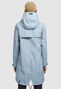 Giacca impermeabile azzurro chiaro con cappuccio, cordino regolabile e apertura posteriore per la traspirabilità. Tessuto liscio e maniche lunghe.