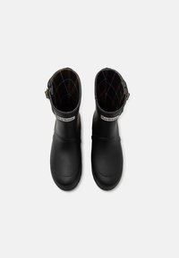 Black rubber ankle boots with a plaid lining, featuring a buckle detail on the side and a rounded toe design.