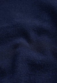 Marineblauer Stoff mit glatter Textur; zeigt ein feines Strickmuster; weist weiche Faltenbildung und leichte Knitter auf.