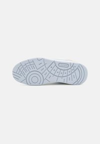 Lacoste sneaker sole, light blue rubber with geometric patterns and textured grips. Features branded logo on the side.