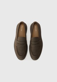 Brown leather slip-on loafers with rounded toe, decorative stitching, and a rubber sole for grip. Interior lined with a soft material.