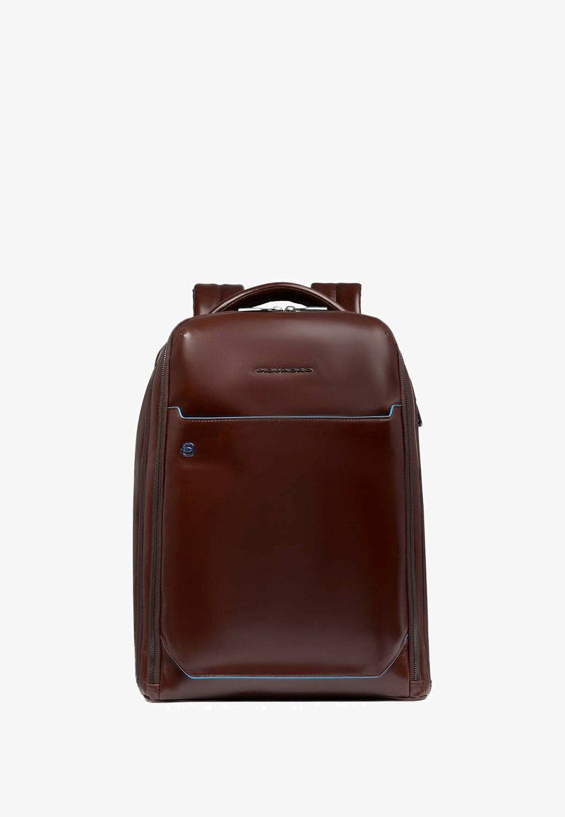 Zaino in pelle marrone con una texture liscia, dotato di una tasca frontale con zip e cuciture decorative blu. Spallacci doppi e manico superiore.