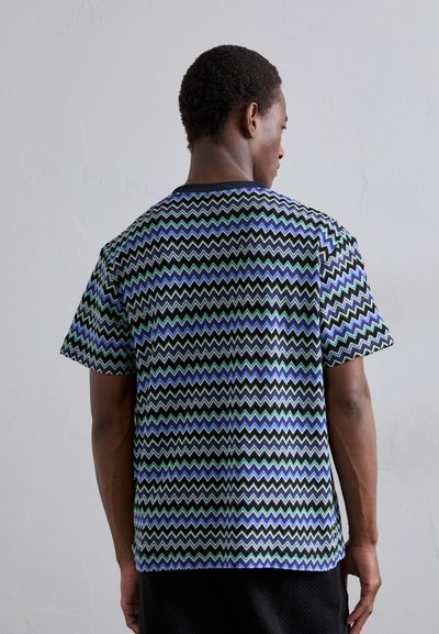 Lühikeste varrukatega, mitmevärviline T-särk, millel on laineline muster sinise, rohelise ja musta tooni ning ümmargune kaelus ja sile tekstuur.