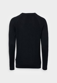 Pulover negru tricotat, cu mâneci lungi, textură ribbed și decolteu rotund. Are o culoare simplă, solidă, fără modele sau accente.