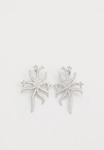 Orecchini in argento con design a stella marina, impreziositi da piccole pietre trasparenti, che mostrano una lavorazione intricata e una superficie strutturata.