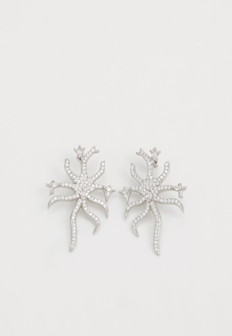 Pendientes de plata con un diseño de estrella de mar, adornados con pequeñas piedras transparentes, que exhiben un detallado intrincado y una superficie texturizada.