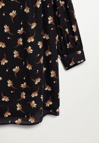 Musta kukkamekko, jossa on kevyt ja valuva kangas, jossa on kerma- ja ruosteenvärisiä kukkakuoseja sekä kerätty hihadesign.