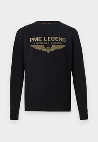 Černá mikina vyrobená z bavlny, s zlatým grafickým potiskem křídel a textem "PME LEGEND AMERICAN CLASSIC" na hrudi.