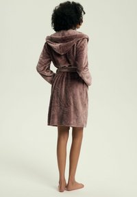 Pluszowy, wrzosowy szlafrok z kapturem i paskiem, z teksturowanym wzorem liści oraz długimi rękawami, sięgający do połowy łydek.