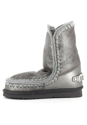 Stivaletto alla caviglia in metallo grigio con una finitura texturizzata, cuciture decorative e un distintivo logo prominente sul lato. Suola morbida per il comfort.