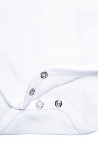 Hvit baby bodysuit i bomull med knapper i bunnen, med runde metallknapper og myk, glatt tekstur.