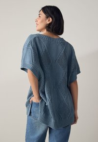 Pulover tricotat bleu deschis, cu croială lejeră, model cu diamante, mâneci scurte, decolteu cu rib și detalii texturate la tiv.