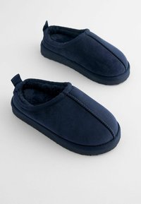 Mörkblåtofflor gjorda av mjukt, texturerat material med en fuskpälsfoder, med rund tå och en baksidesdragflik för enkel påtagning.