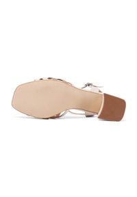 Sandal con tacco rosa chiaro con suola marrone texture. Presenta cinturini intrecciati e una cinturino alla caviglia regolabile per una vestibilità sicura.