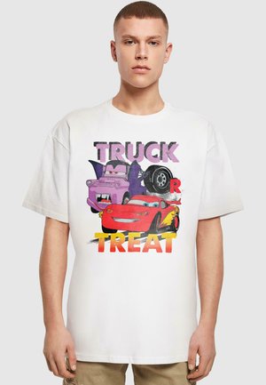 Balta kokvilnas grafiskā t-kreklu ar krāsainu karikatūru automašīnu druku, ar tekstu "TRUCK OR TREAT" treknajā, spēlīgajā fontā. Īsās piedurknes.