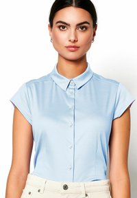 Light blue short-sleeve shirt featuring a collared neck and button front. Made of smooth fabric with subtle sheen; sleeves have purple accents.