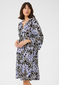 Blumenkleid mit schwarzem Hintergrund und blau-weißer Leopardenmusterung. Lockere, lange Ärmel und ein V-Ausschnitt-Design. Leichter Stoff.
